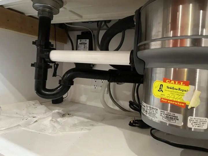 New garbage disposal installed under a kitchen sink