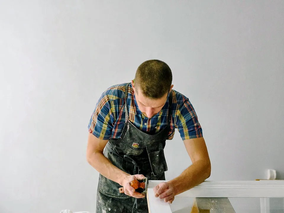 Carpenter measuring and cutting trim