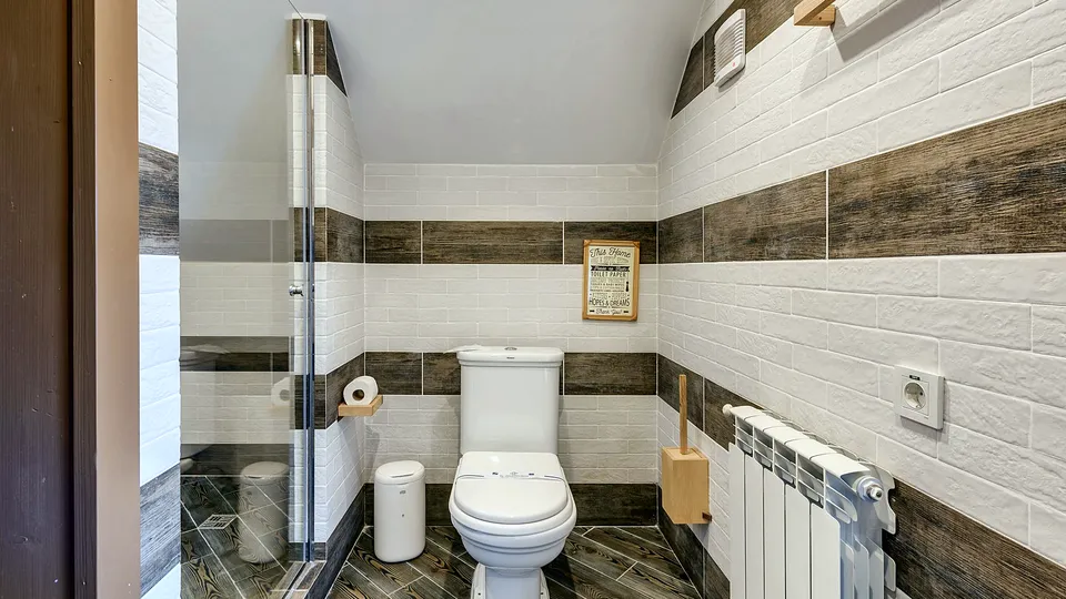 Small bathroom with tile walls and a radiator
