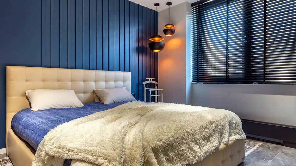 Bedroom with horizontal blinds on a wide window
