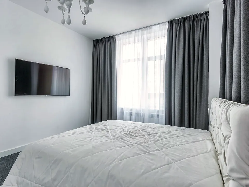 Long curtains hung from a rod across a bedroom window