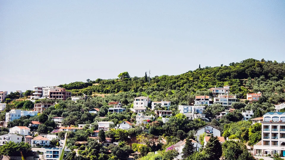 Homes spread across a green hillside