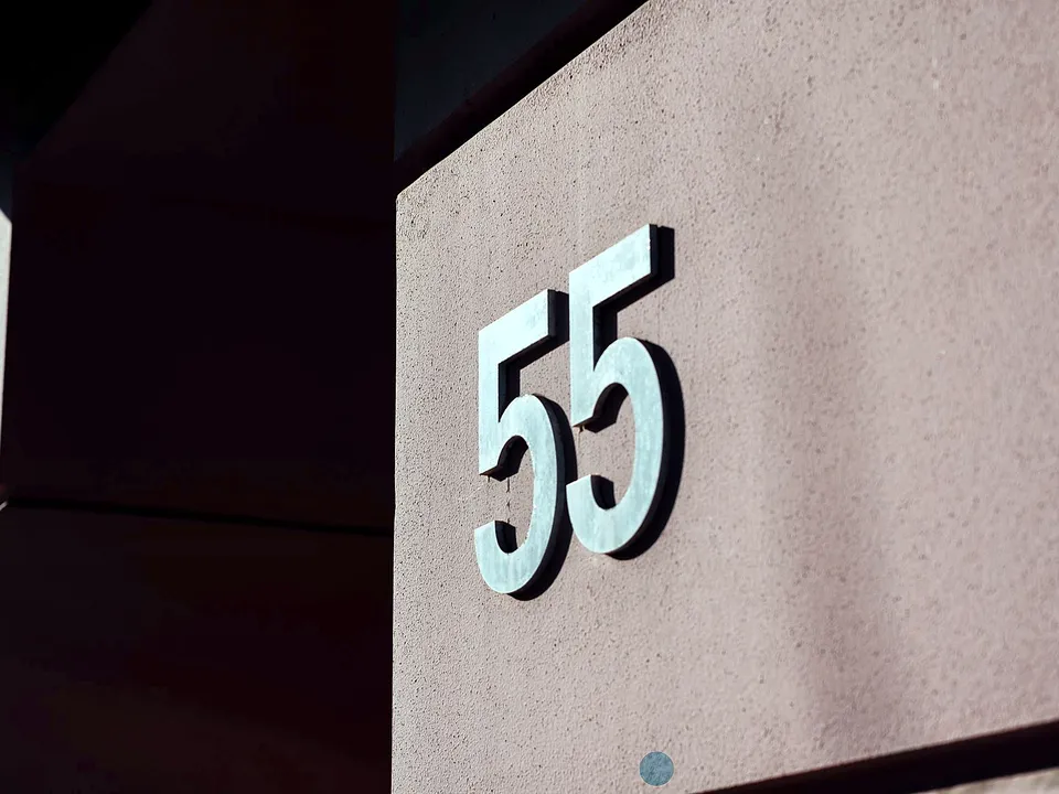 Modern metal house numbers on a wall