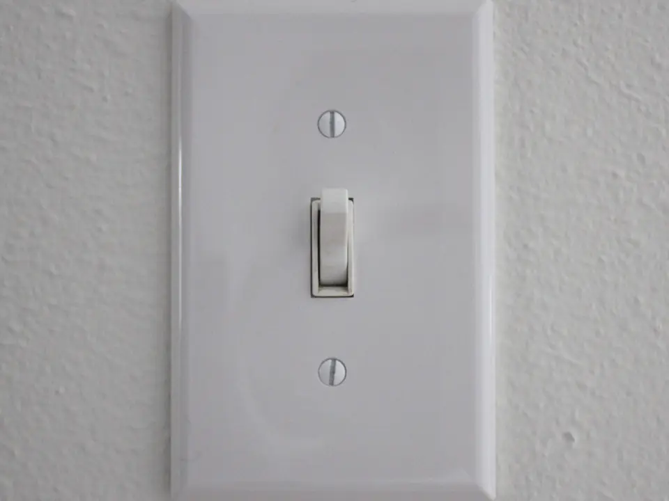 White toggle light switch on a textured wall