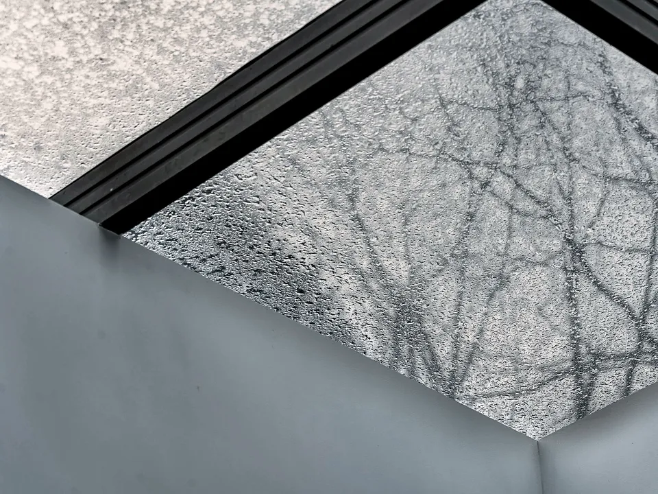 Textured ceiling meeting a window frame