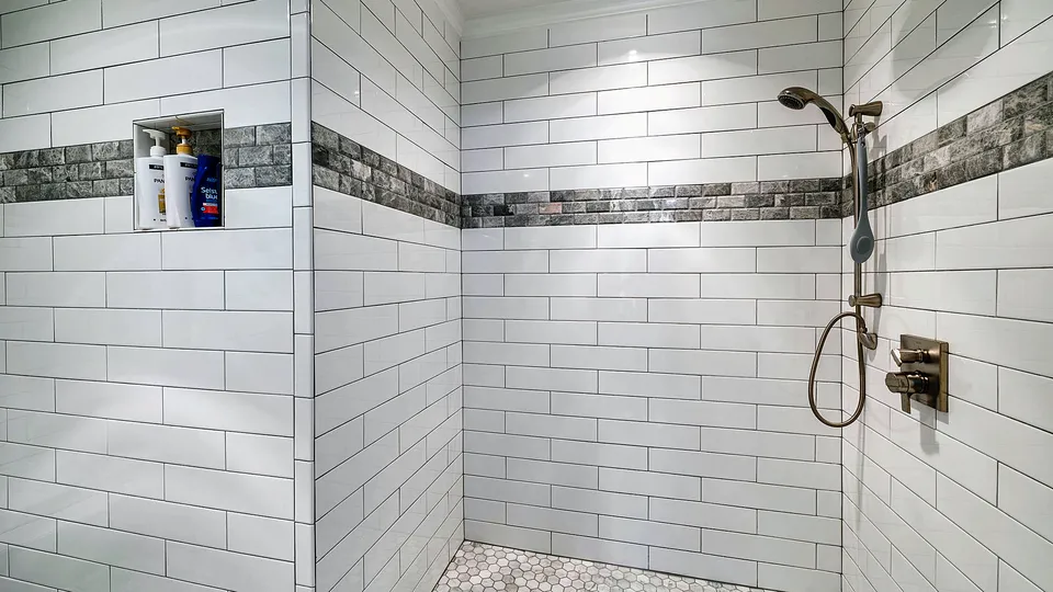 Tiled walk-in shower with a mosaic accent band