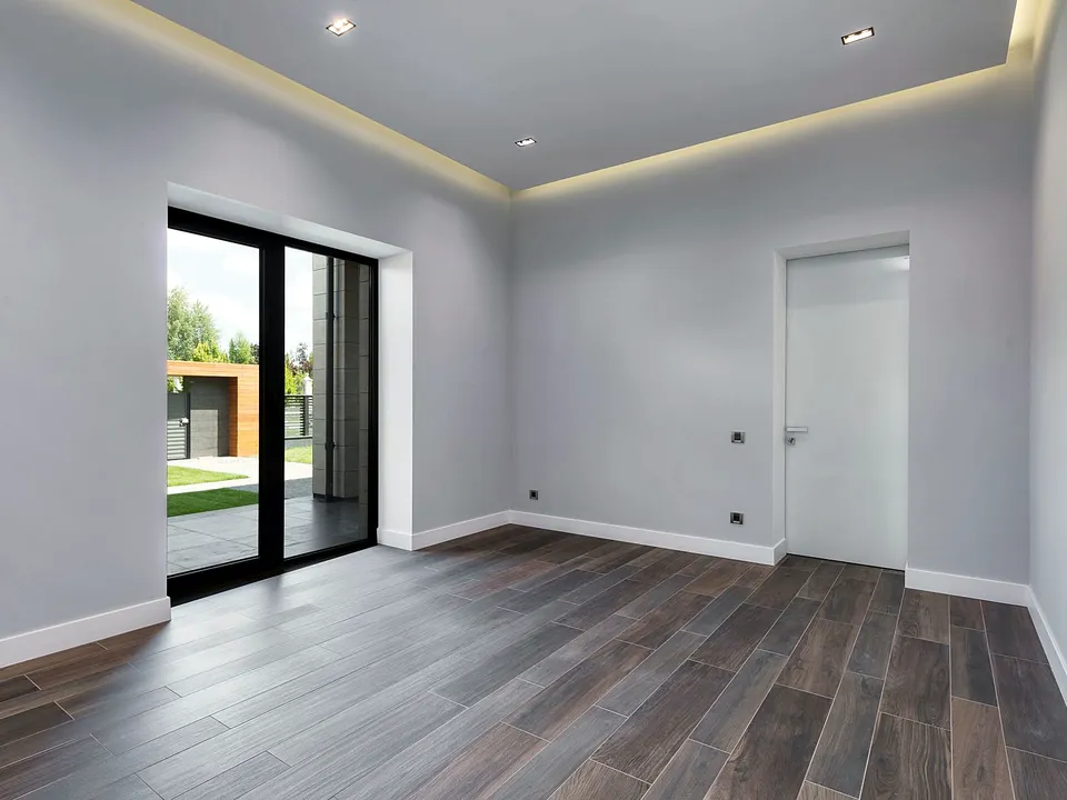 Empty room with recessed ceiling lights and a glass door