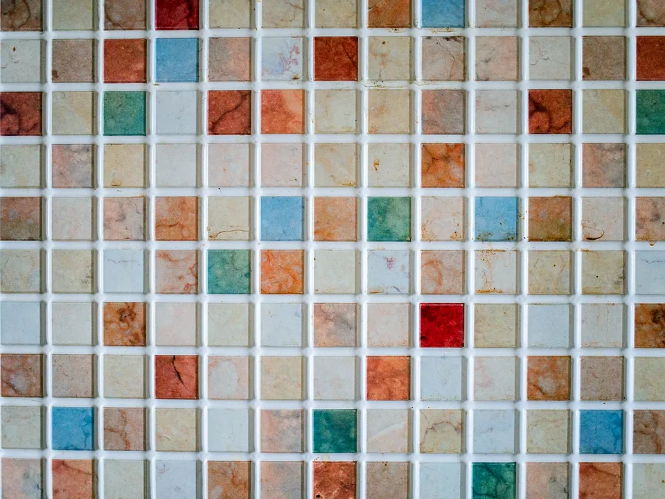 Wall of small square tiles in mixed colors with grout lines