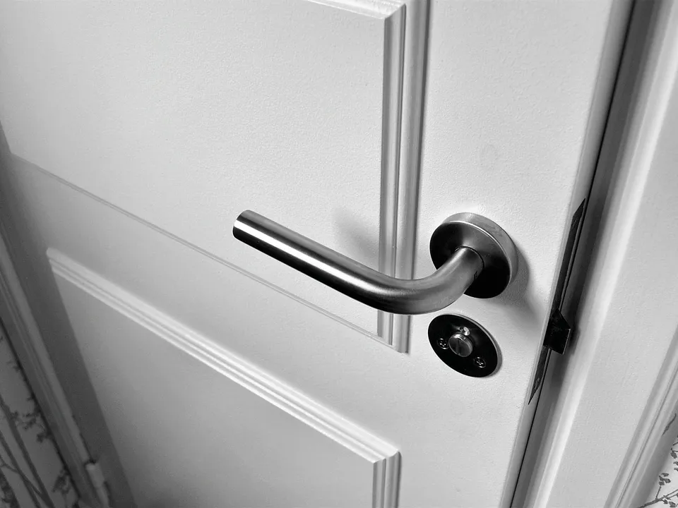 Chrome lever handle on a white door