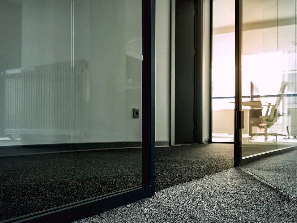 Glass door panels meeting a floor track