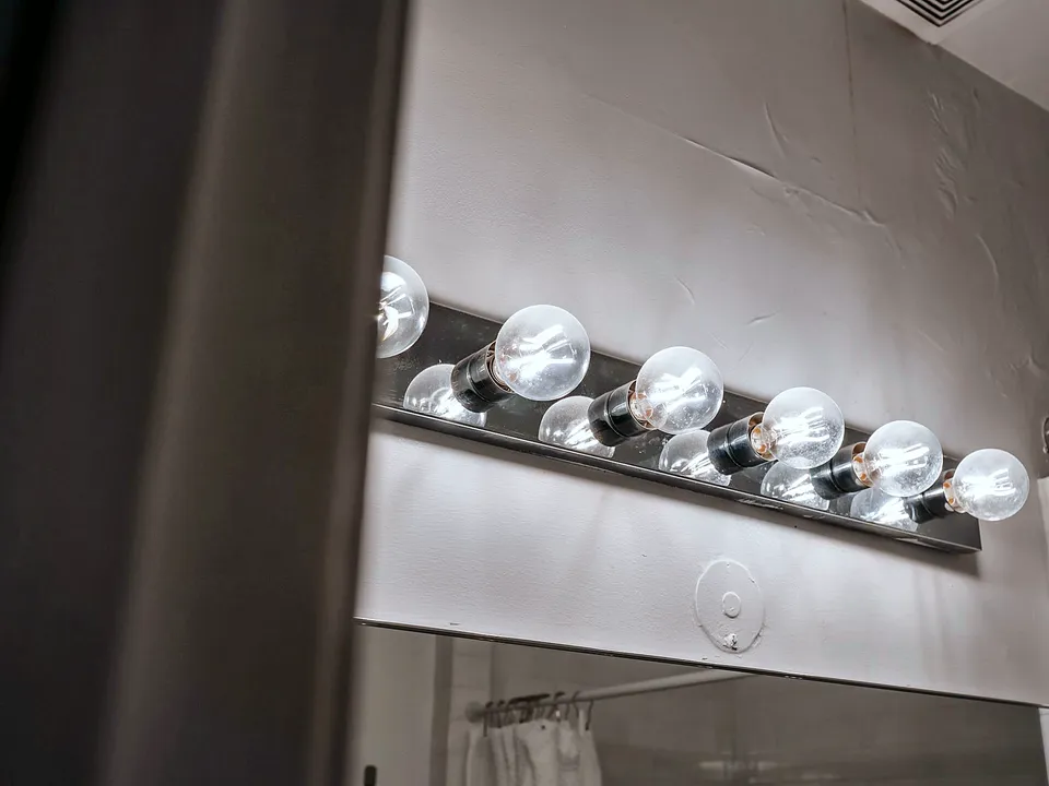 Globe-bulb vanity light bar above a mirror