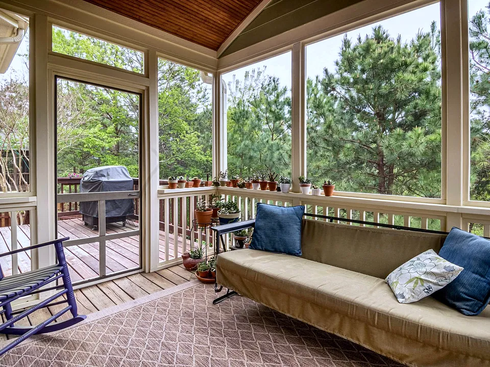 Screened-in porch with a cushioned bench