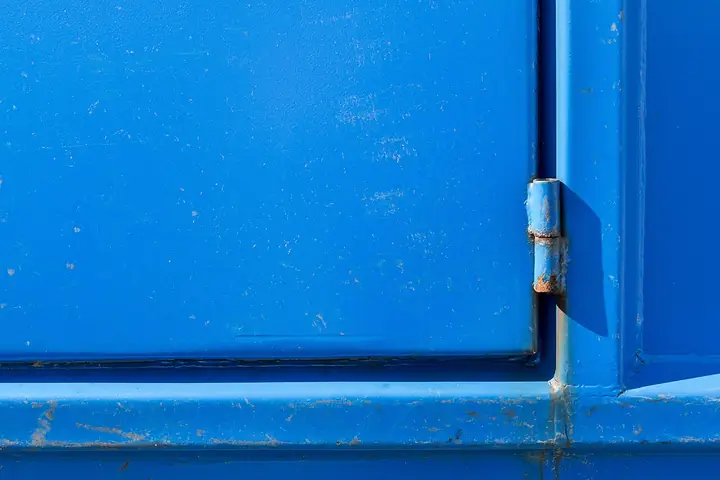 Hinge on a blue painted door