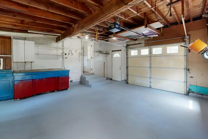 Empty garage with open space and colorful storage cabinets
