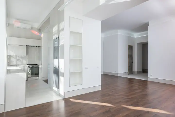 Modern interior featuring an open kitchen and living area with wooden flooring