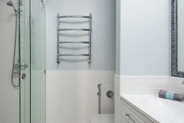Interior of modern bathroom with sink on cabinet and toilet at wall near glass door of shower cabin at home