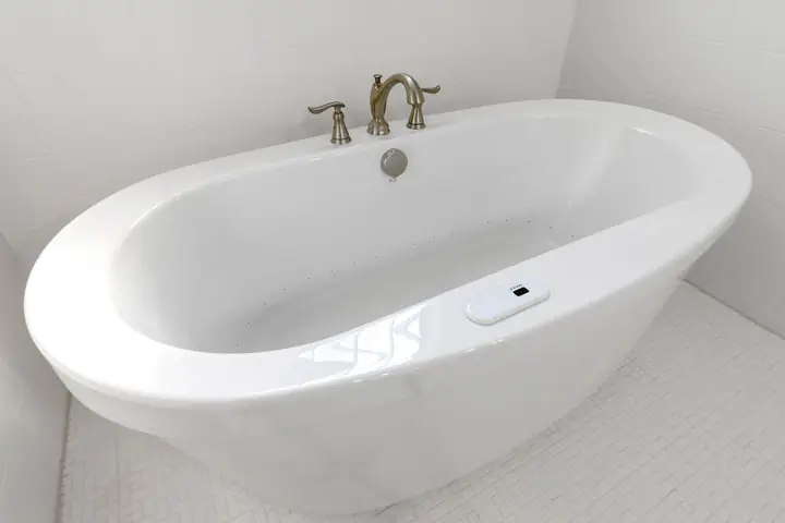 A clean and empty white porcelain bathtub in a minimalist bathroom