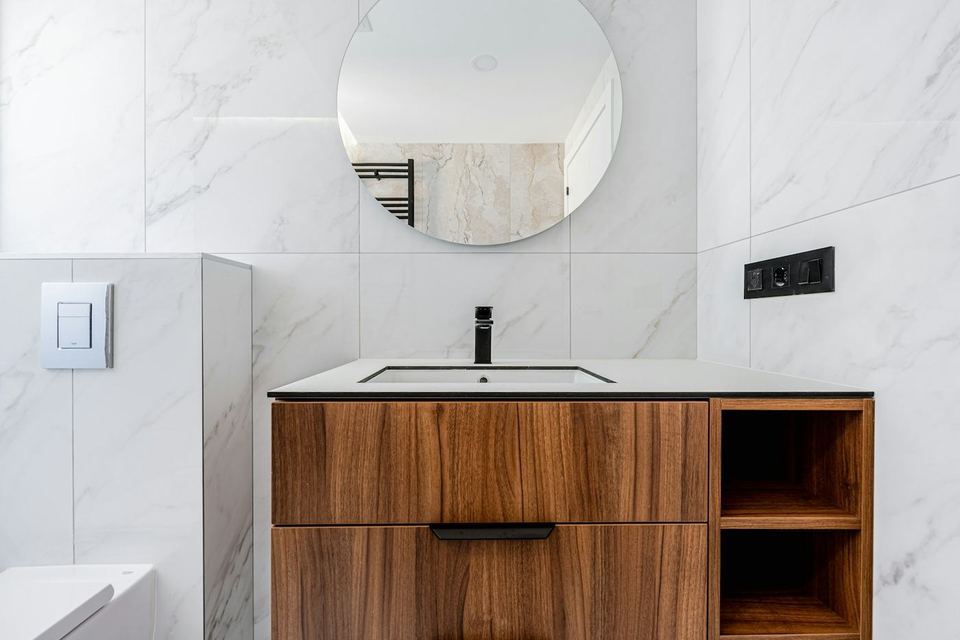 A bathroom with a modern vanity and fixtures